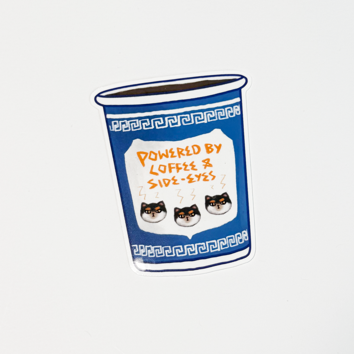 A die-cut sticker featuring a blue coffee cup with white Greek key patterns and three cartoon cats labeled 'Side-Eyes'. The sticker has a white label in the center with orange text reading 'POWERED BY LOFFE & SIDE-EYES' and three small cat faces.