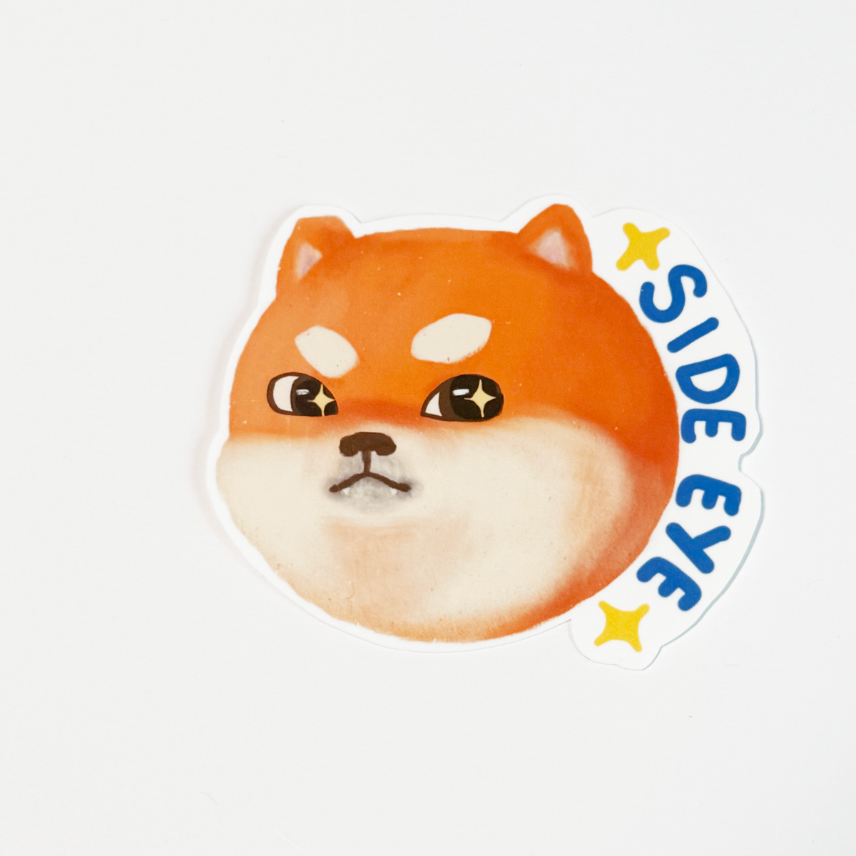 A die-cut sticker featuring a cartoon Shiba Inu dog face with the text 'SIDE EYE' and yellow stars on a white background.